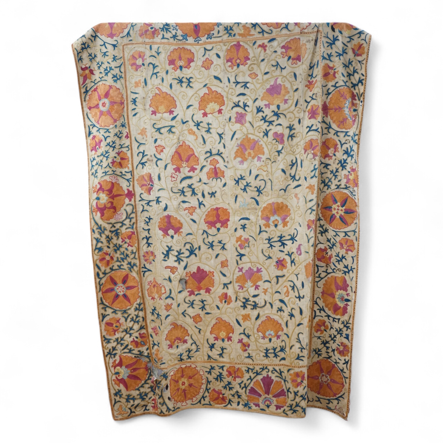A 19th century, circa 1850-1880 hand embroidered Suzani wall hanging, probably from Uzbekistan. Worked on had woven linen, predominantly embroidered in orange, ochre, maroon and green silks in fine chain stitch with an o